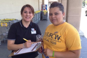 An assistant manager at Big Lots signs a petition in support of Food 4 Less workers at the Local 1428 action.