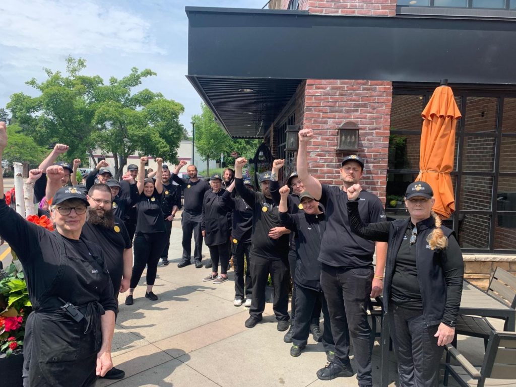 Grocery workers raised their fists in solidarity outside of a Kowalski's Market